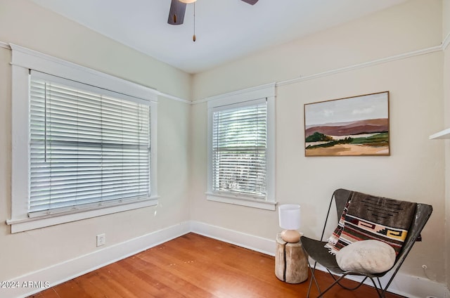 sitting room with wood finished floors, baseboards, and ceiling fan