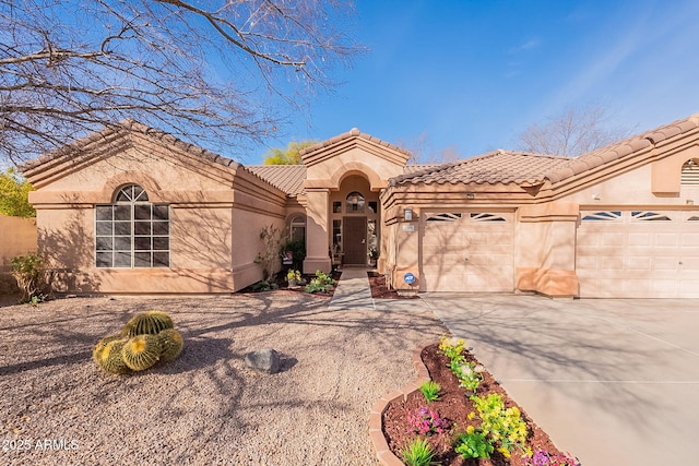 mediterranean / spanish home featuring a garage, driveway, a tile roof, and stucco siding