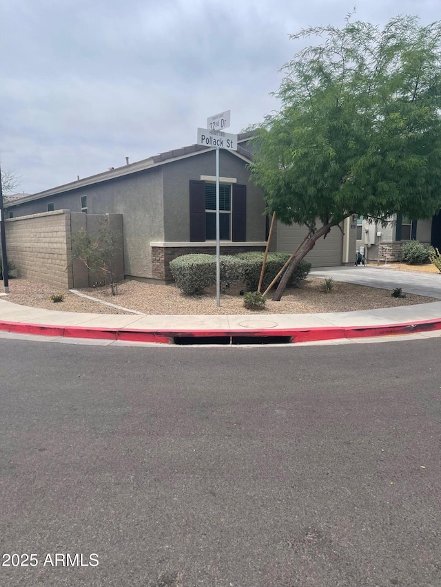 3211 W Pollack St, Phoenix, AZ 85041 - view of front of house featuring stucco siding, fence, and driveway