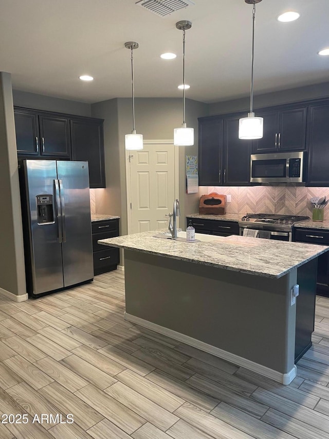 3211 W Pollack St, Phoenix, AZ 85041 - kitchen with appliances with stainless steel finishes, a sink, wood tiled floors, light stone countertops, and recessed lighting