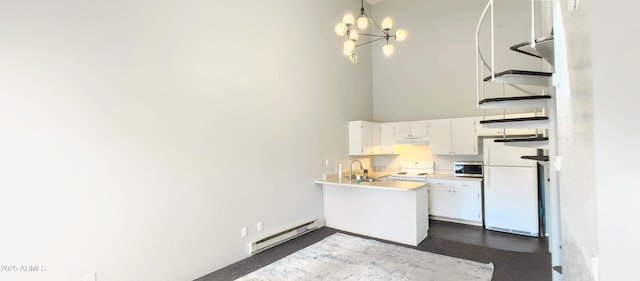 kitchen featuring sink, decorative light fixtures, a baseboard radiator, white appliances, and white cabinets