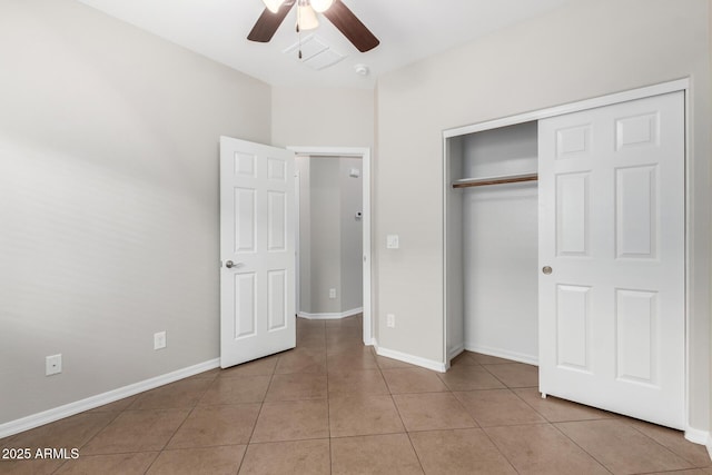 unfurnished bedroom with a ceiling fan, light tile patterned floors, baseboards, and a closet