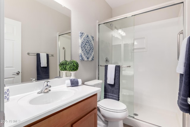 bathroom featuring vanity, toilet, and a stall shower