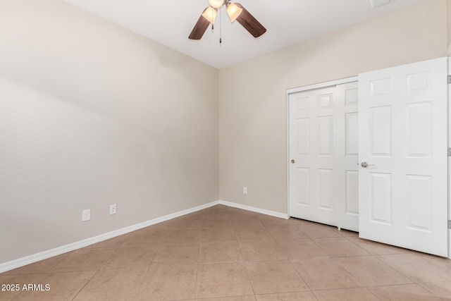 unfurnished bedroom with visible vents, baseboards, light tile patterned floors, a closet, and a ceiling fan