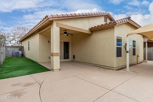 back of house featuring a ceiling fan, fence, a yard, stucco siding, and a patio area