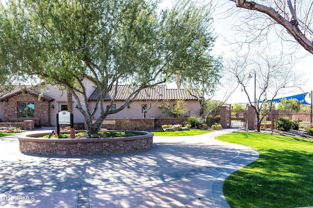 exterior space with fence, a lawn, driveway, and a gate