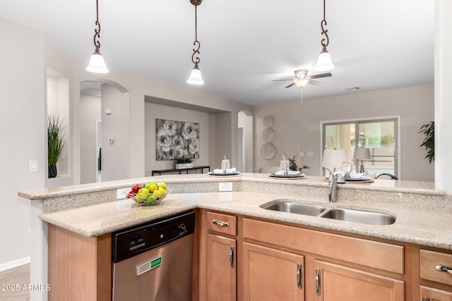 kitchen featuring light stone counters, arched walkways, a sink, pendant lighting, and stainless steel dishwasher