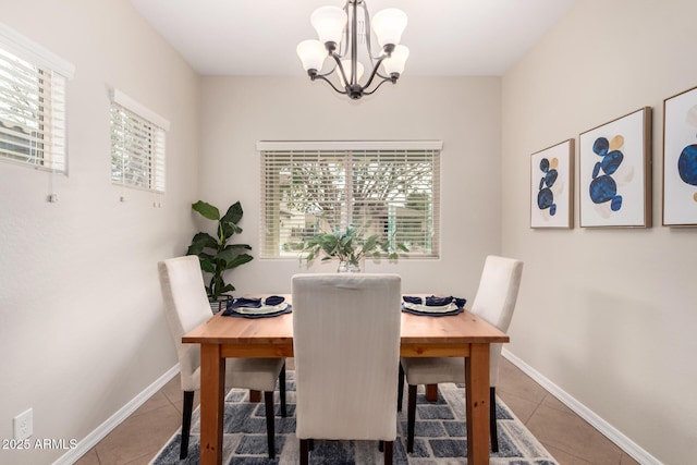 tiled dining room with a wealth of natural light, baseboards, and an inviting chandelier