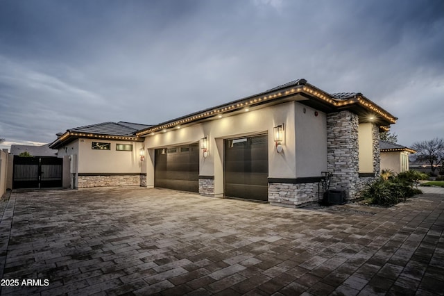 view of front of house featuring a garage and central AC