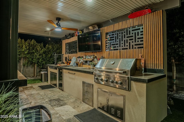 view of patio with ceiling fan, grilling area, beverage cooler, and exterior kitchen