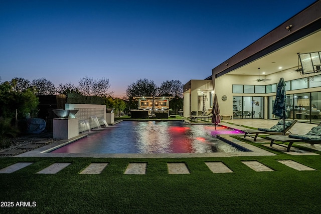 view of swimming pool featuring pool water feature, ceiling fan, and a patio