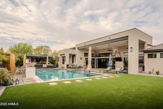 view of pool featuring a patio, a bar, a lawn, area for grilling, and ceiling fan