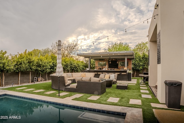 view of swimming pool featuring an outdoor living space, a lawn, a patio, and exterior bar