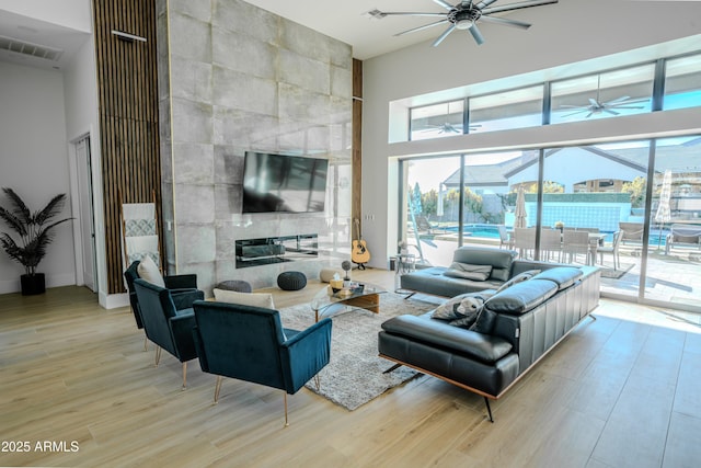 living room featuring light hardwood / wood-style flooring, a wealth of natural light, and ceiling fan