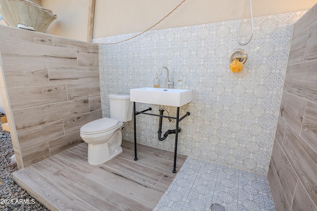 bathroom with sink, hardwood / wood-style flooring, a shower, and toilet