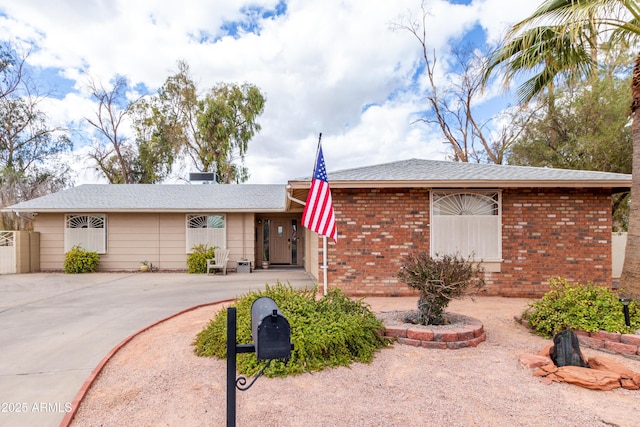 ranch-style house featuring driveway and brick siding