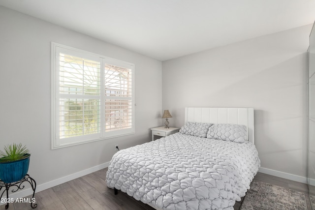 bedroom with baseboards and wood finished floors