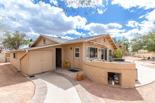 view of front of property with a shingled roof, fence, and a patio