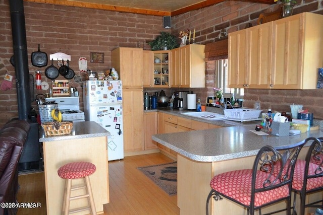 3733 Del Contento Rd, Snowflake, AZ 85937 - kitchen featuring white appliances, a sink, brick wall, a peninsula, and light wood-type flooring