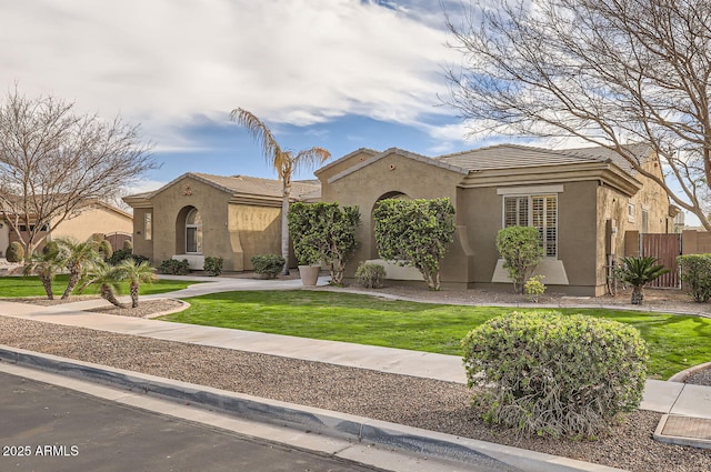 8115 W San Miguel Ave, Glendale, AZ 85303 - mediterranean / spanish house with fence, stucco siding, a tile roof, and a front lawn