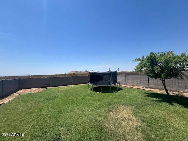 5881 E Sunrise Cir, Florence, AZ 85132 - view of yard featuring a trampoline and a fenced backyard