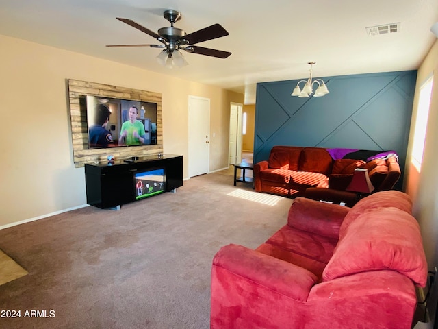 carpeted living room with ceiling fan with notable chandelier