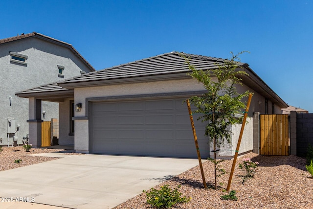 17032 W Cavedale Dr, Surprise, AZ 85387 - view of front of house featuring a tile roof, stucco siding, an attached garage, driveway, and a gate