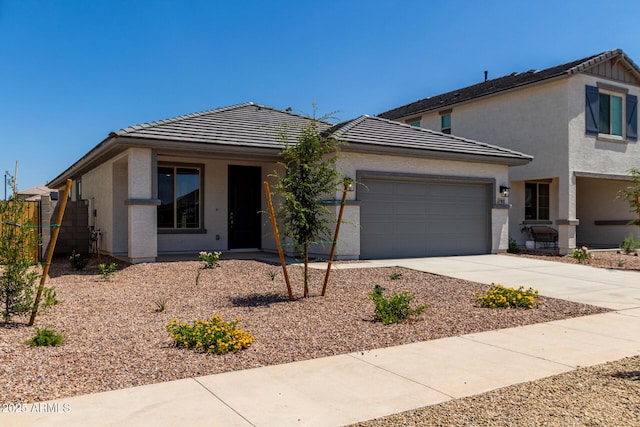 17032 W Cavedale Dr, Surprise, AZ 85387 - view of front of house with a tiled roof, a garage, concrete driveway, and stucco siding