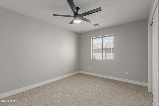 carpeted spare room featuring ceiling fan