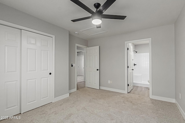 unfurnished bedroom with ceiling fan, ensuite bathroom, light colored carpet, and a closet