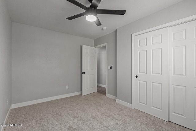 unfurnished bedroom featuring light colored carpet, a closet, and ceiling fan