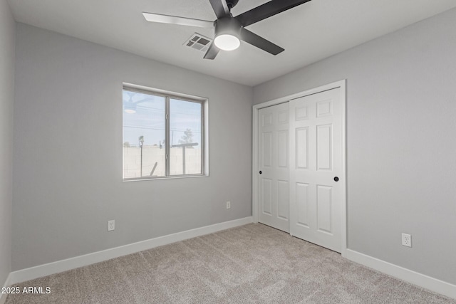 unfurnished bedroom with light carpet, ceiling fan, and a closet