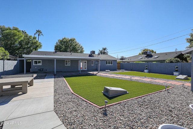 back of property featuring a lawn and a patio