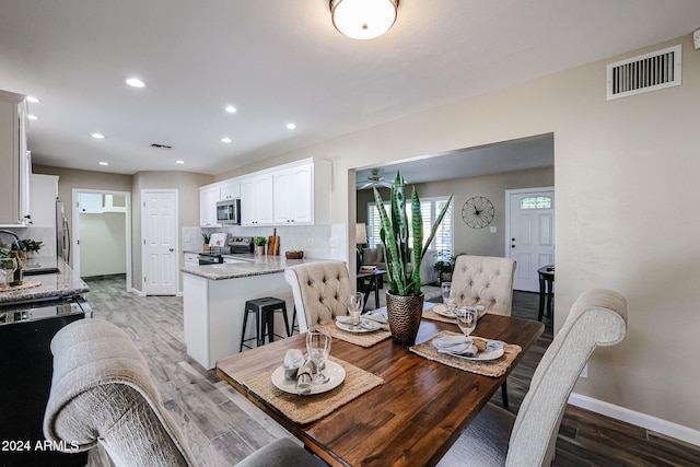 dining room with hardwood / wood-style floors and sink