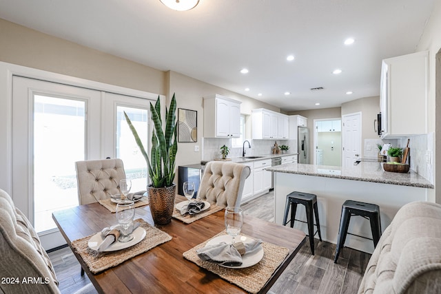 dining area featuring sink, wood-type flooring, and french doors