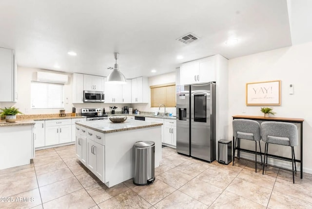 16436 N 64th Pl, Scottsdale, AZ 85254 - kitchen with stainless steel appliances, a kitchen island, white cabinetry, a sink, and light stone countertops