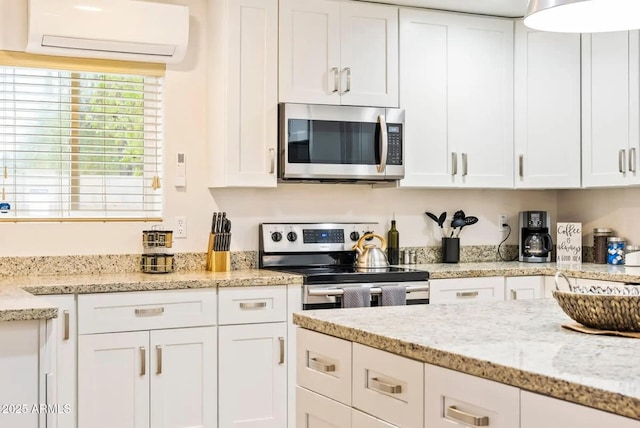 16436 N 64th Pl, Scottsdale, AZ 85254 - kitchen featuring stainless steel appliances, a wall mounted AC, white cabinetry, and light stone countertops