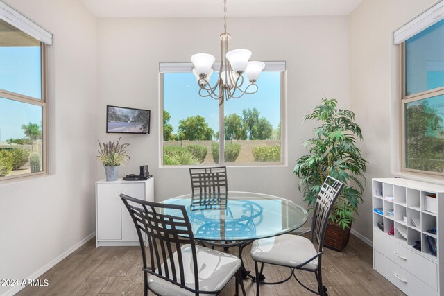 dining room featuring an inviting chandelier, hardwood / wood-style flooring, and plenty of natural light