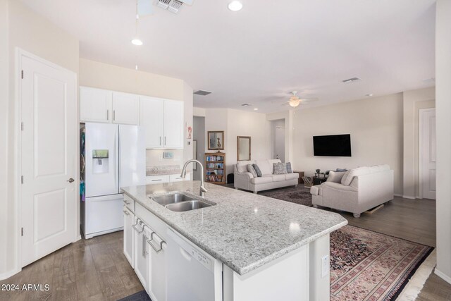 kitchen featuring white appliances, white cabinets, hardwood / wood-style floors, sink, and a center island with sink