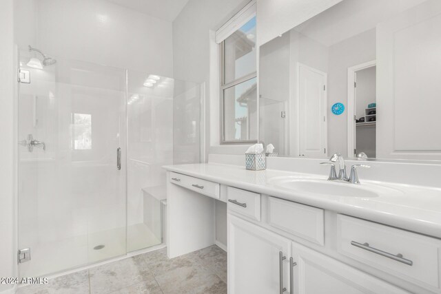 bathroom featuring tile patterned flooring, a shower with shower door, and vanity