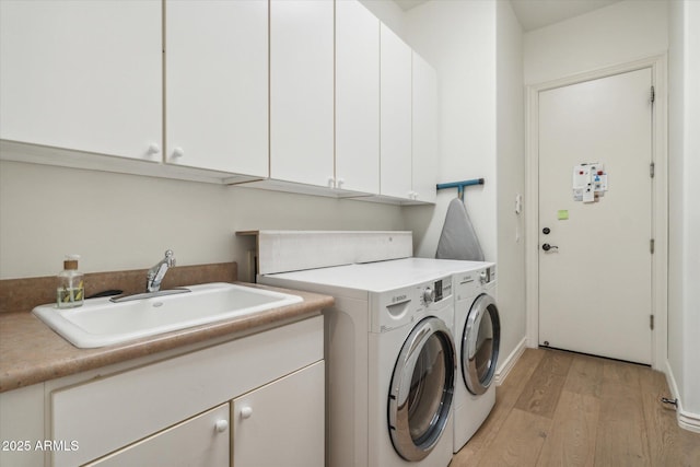 washroom with cabinets, separate washer and dryer, sink, and light hardwood / wood-style flooring