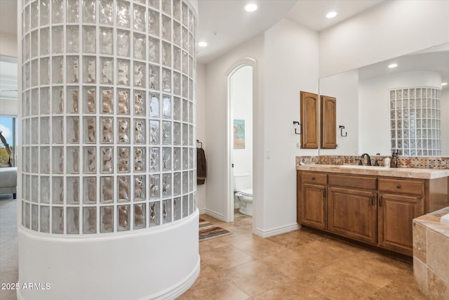 bathroom with a towering ceiling, vanity, and toilet