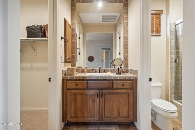 bathroom with vanity, an enclosed shower, and toilet