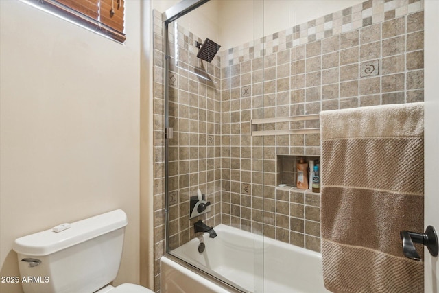 bathroom with enclosed tub / shower combo and toilet