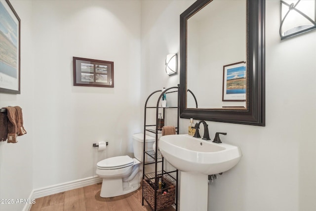 bathroom featuring hardwood / wood-style flooring and toilet