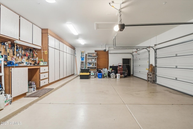 garage with a garage door opener and a workshop area