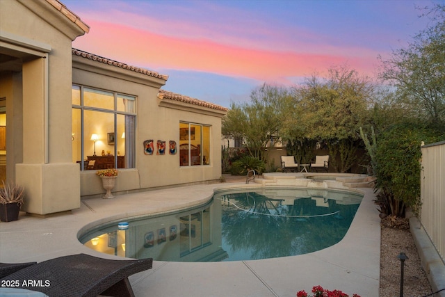 pool at dusk with a patio