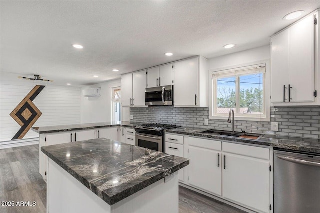 118 S 700th St E, Taylor, AZ 85939 - kitchen with appliances with stainless steel finishes, a sink, a peninsula, a wall mounted AC, and dark wood finished floors