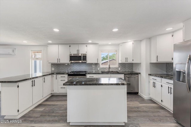 118 S 700th St E, Taylor, AZ 85939 - kitchen featuring stainless steel appliances, a peninsula, a wall mounted AC, white cabinets, and backsplash