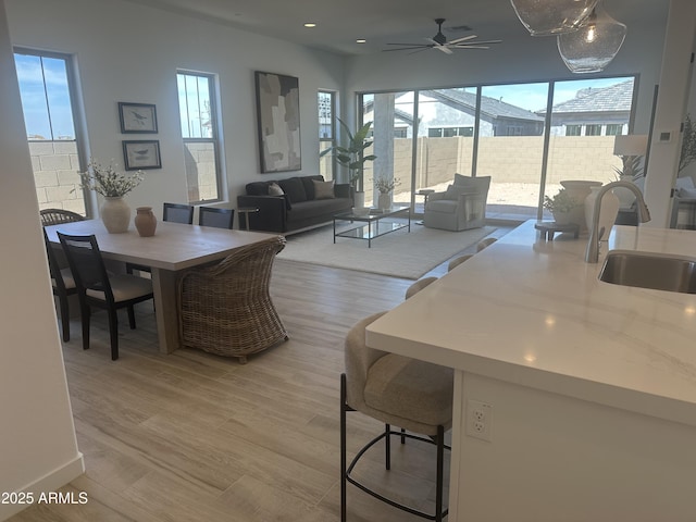 dining space featuring a ceiling fan, plenty of natural light, light wood finished floors, and recessed lighting